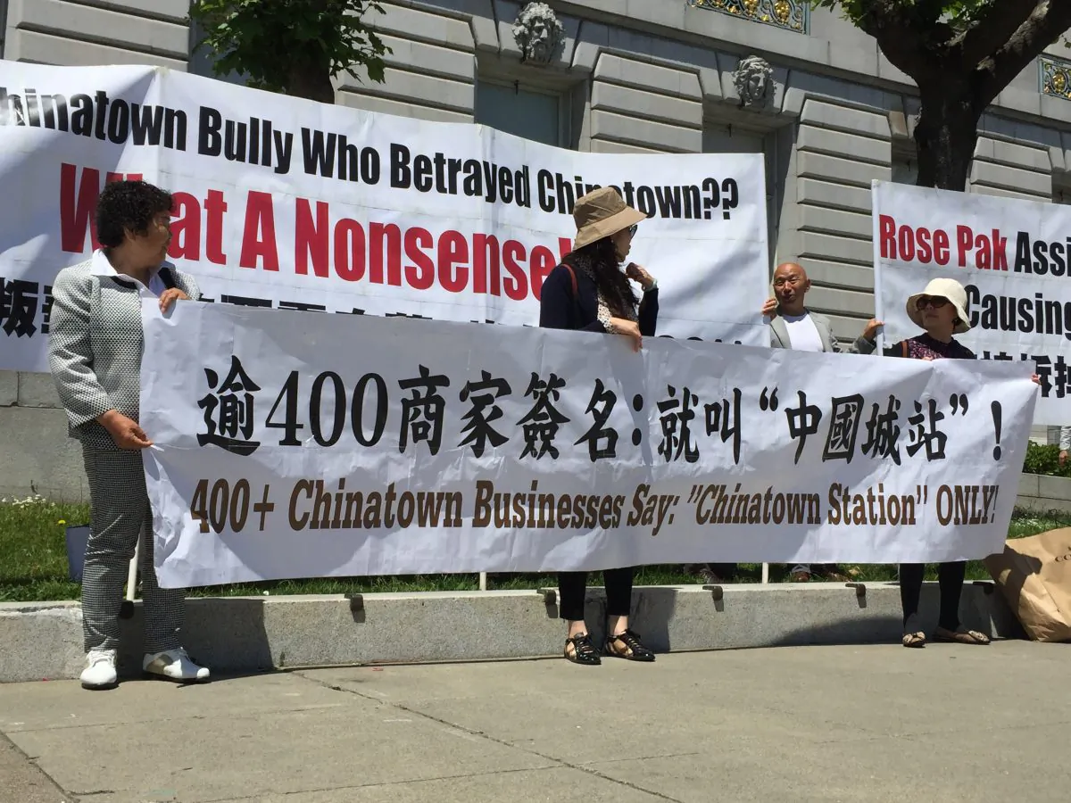 People holding signs in front of San Francisco City Hall to show their opposition to using Rose Pak's name for Chinatown Station on June 4 , 2019 (Cynthia Cai/Epoch Times)