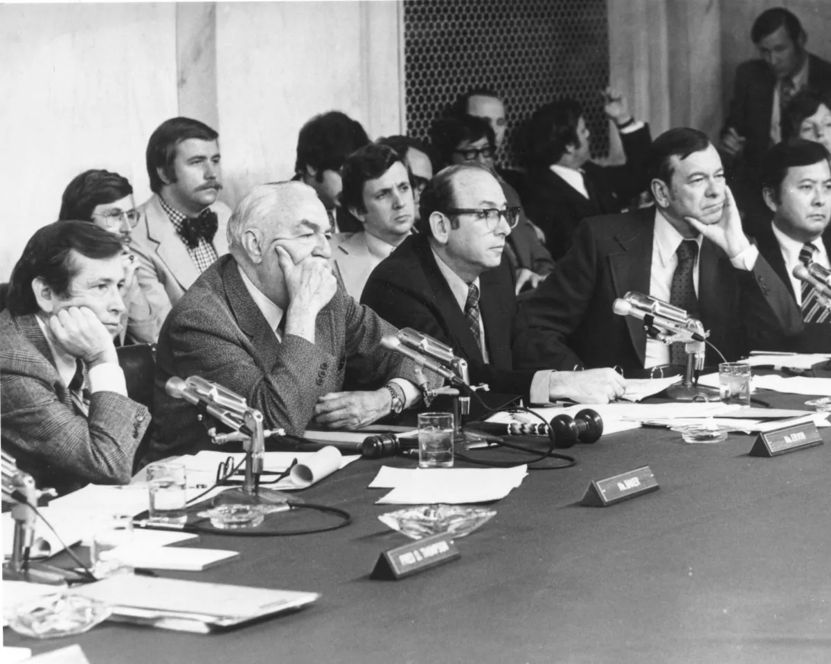 American politicians, (L-R) Sen. Howard Baker (Tenn.), Sen. Sam Irvin of (N.C.), Majority Council Sam Dash, Sen. Herman E. Talmadge (Ga.), and Sen. Daniel Inouye (Hawaii), listen to the testimony of James McCord, one of the Watergate burglars, during the Watergate hearings. (Gene Forte/Getty Images)