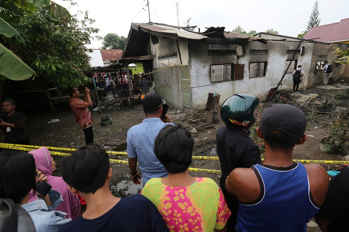 Locals look at a house used as a factory