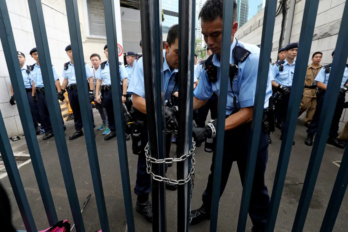 Police officers lock the gate of a police headquarter after protesters attempt to storm in, in Hong Kong, China on June 21, 2019. (Ann Wang/Reuters)