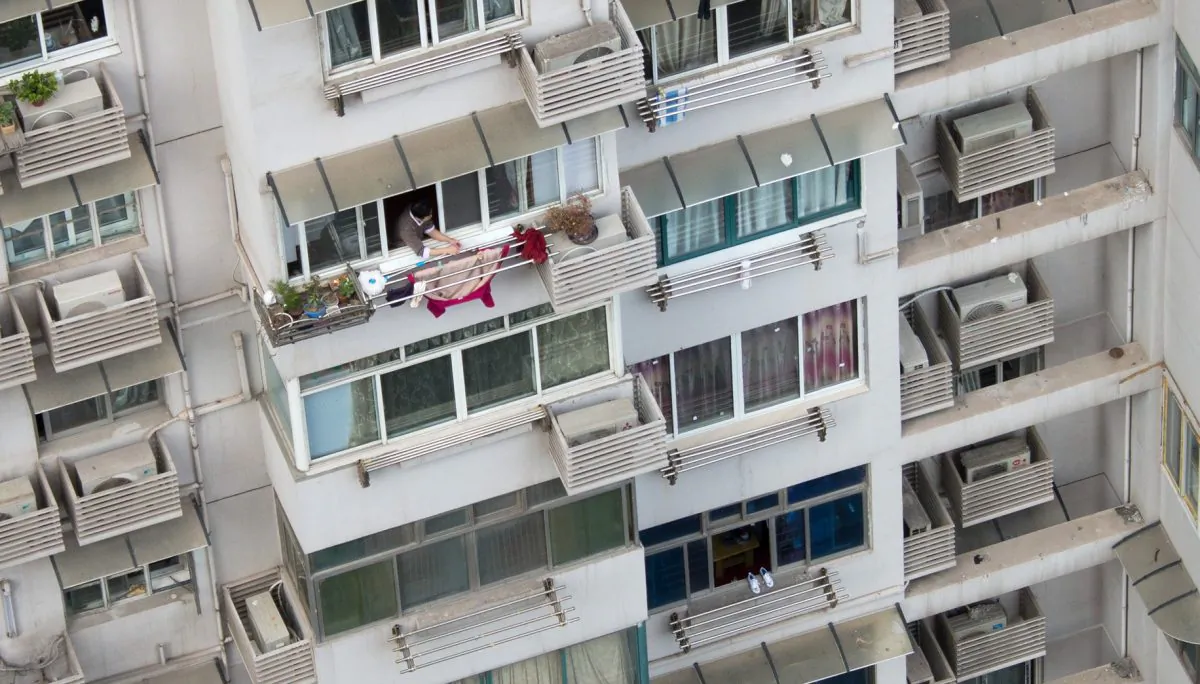 A man hanging clothes off his balcony. (Johannes Eisele/AFP/Getty Images)