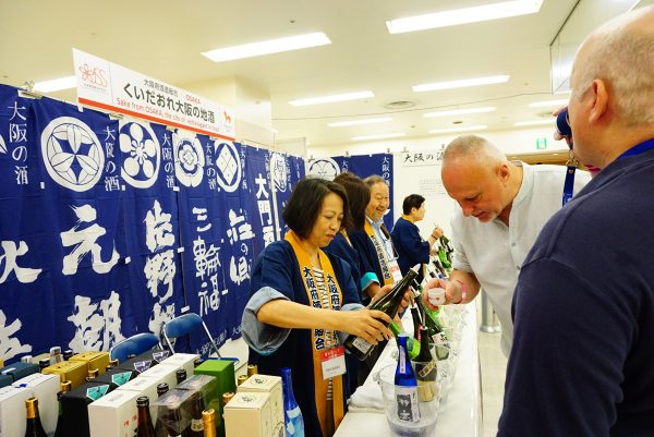 international visitors taste sake at the japanese sake fair in tokyo