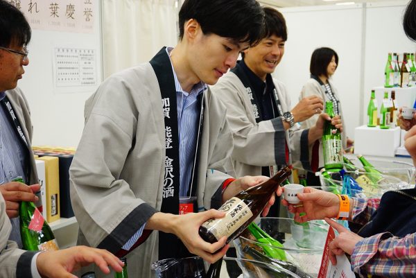 man enjoys a sample of sake at the japanese sake fair in tokyo