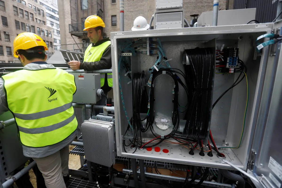 Sprint technicians work on the installation of 5G technology next to fiber cables on top of a building in New York City, U.S. on June 11, 2019. (Shannon Stapleton/Reuters)
