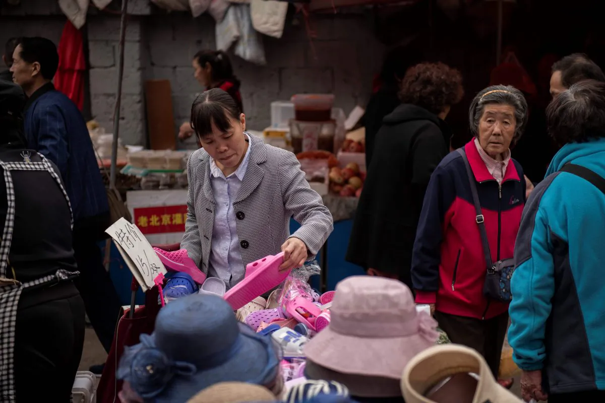 A woman looks at shoes at a market in Beijing on April 23, 2019. (Nicolas Asfouri/AFP/Getty Images)