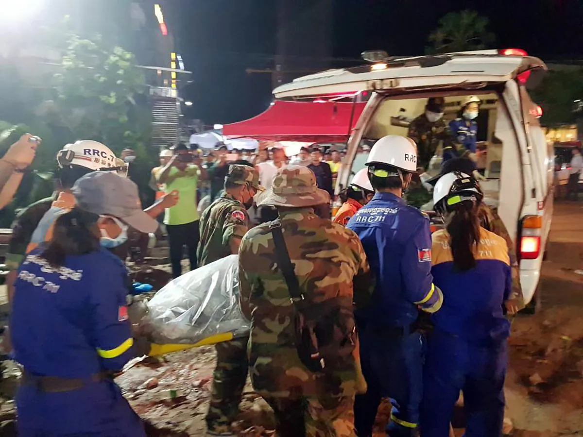 Rescuers enter a victim onto an ambulance at a site of a collapse in Preah Sihanouk Province, Cambodia on June 23, 2019. Rescuers on June 24 were continuing to search the rubble of a building that collapsed while under construction in a Cambodia beach town, killing dozens of workers as they slept in the unfinished condominium that was doubling as their housing. (Preah Sihanouk provincial authorities via AP)