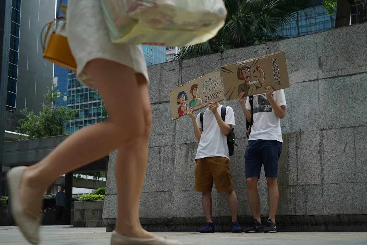 Protestors hold up signs to apologize for a demonstration that jammed the entrance of a government tax office in Hong Kong on June 25, 2019. Hong Kong protestors handed out flyers, held up signs, and bowed to passersby Tuesday to apologize for a sit-in demonstration the day before that blocked access to a government office for nearly two hours. (Dake Kang/AP)