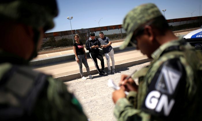 Members of Mexico's National Guard detain Cuban migrants after they were trying to cross illegally the border between the U.S. and Mexico, in Ciudad Juarez, Mexico June 21, 2019. (Reuters/Jose Luis Gonzalez)