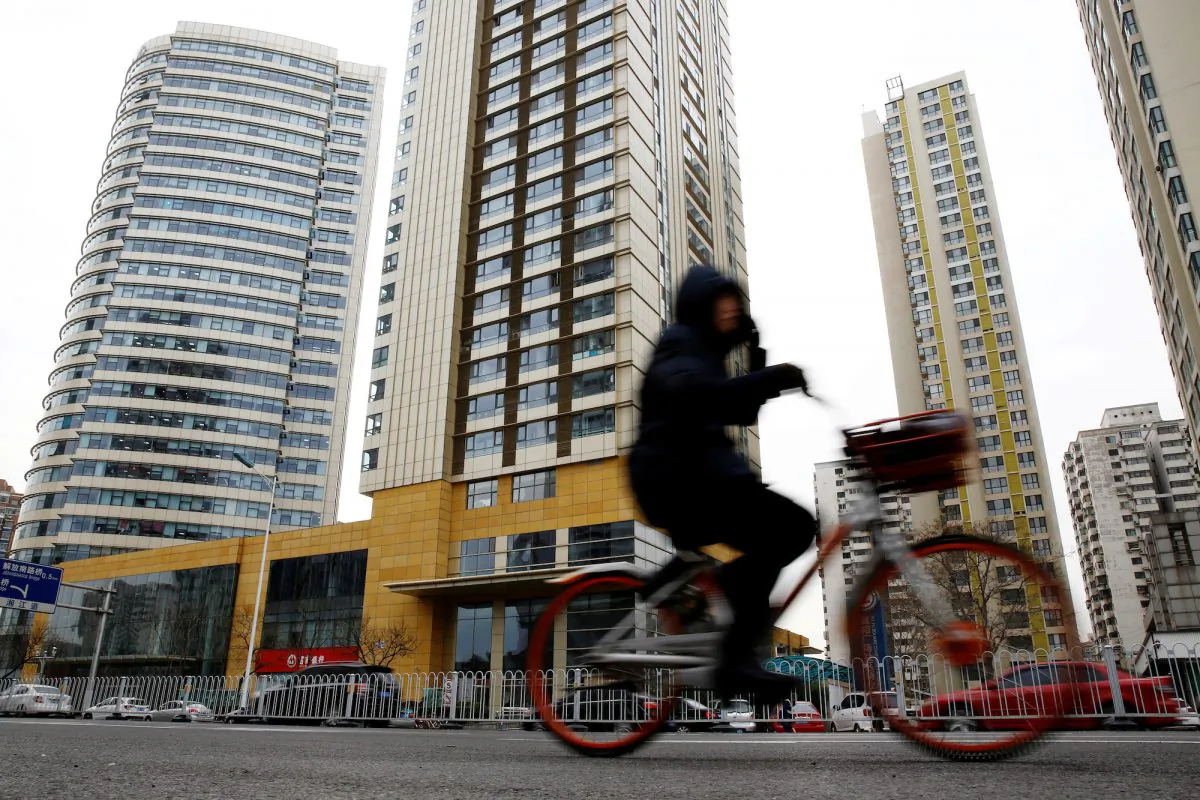A woman cycles past a building in Tianjin, China, on Dec. 21, 2018. (Thomas Peter/Reuters)