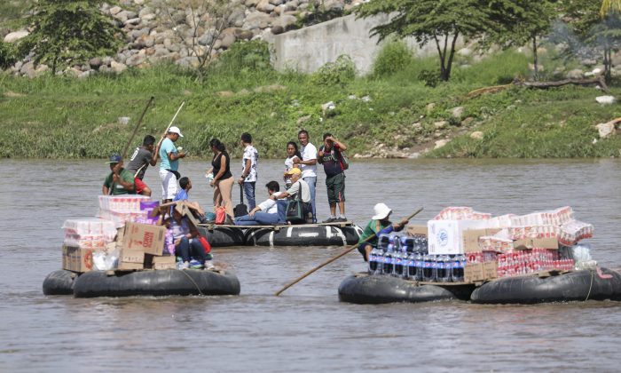 Tube rafts carry people and goods across the Suchiate River from Hidalgo, Mexico, to Tecun Uman, Guatemala, on June 25, 2019. (Charlotte Cuthbertson/The Epoch Times)