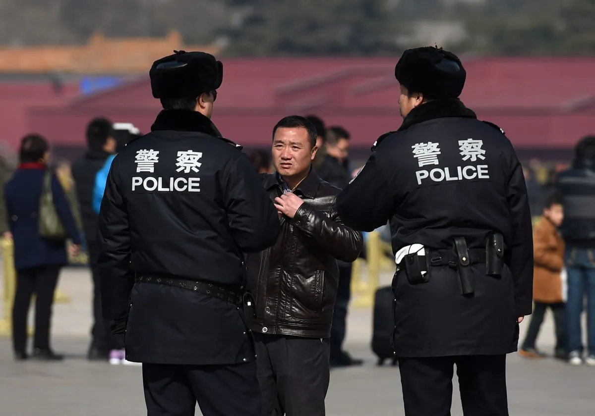 Chinese police question a man (C) in Tiananmen Square in Beijing on March 2, 2015. (Greg Baker/AFP/Getty Images)