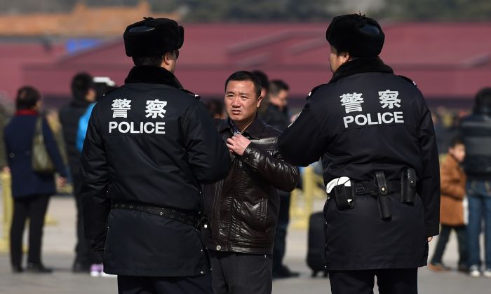 Chinese police question a man (C) in Tiananmen Square in Beijing on March 2, 2015. (Greg Baker/AFP/Getty Images)