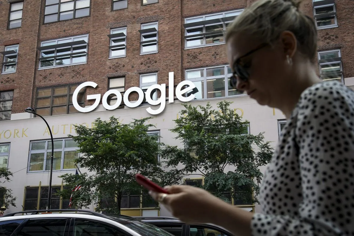 A woman looks at her smartphone as she walks past Google Building 8510 at 85 10th Ave  in New York City, on June 3, 2019. (Drew Angerer/Getty Images)