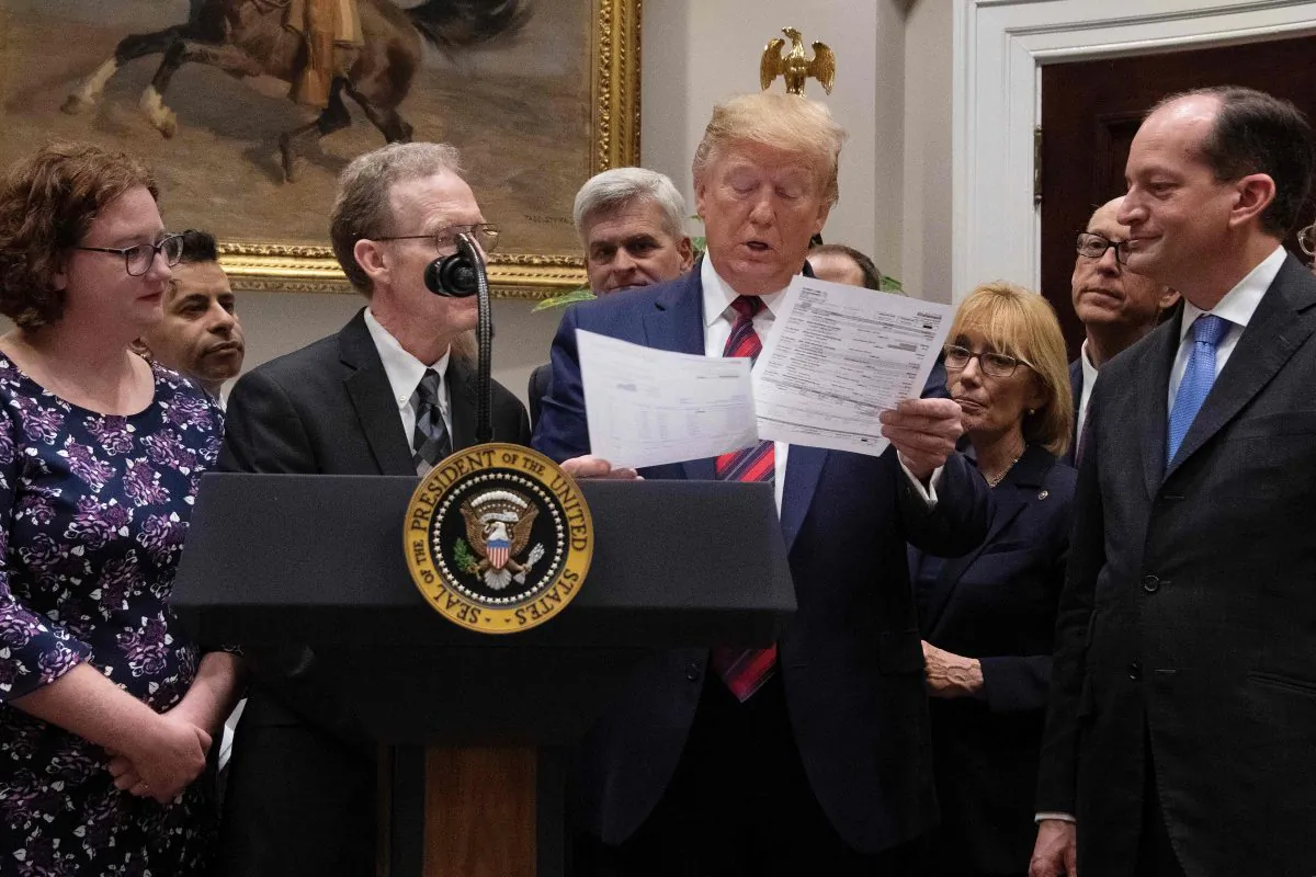 President Donald Trump (C) looks at a medical bill as he speaks during an event on ending surprise medical billing, at the White House on May 9, 2019. (JIM WATSON/AFP/Getty Images)