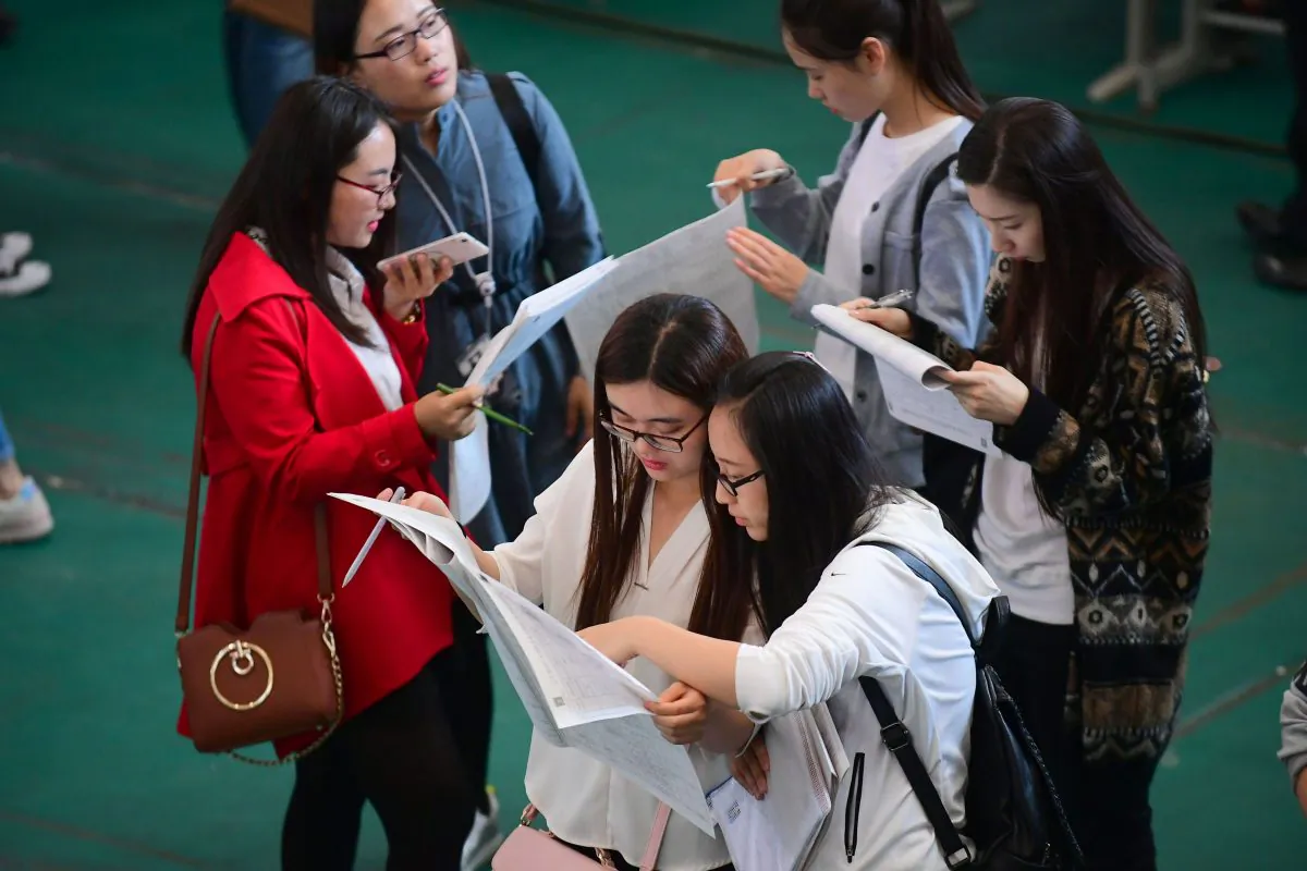 Young adults looking at postings at a job fair at Shenyang Aerospace University in Shenyang, in China's northeast Liaoning Province on May 13, 2017. (China OUT/STR/AFP/Getty Images)