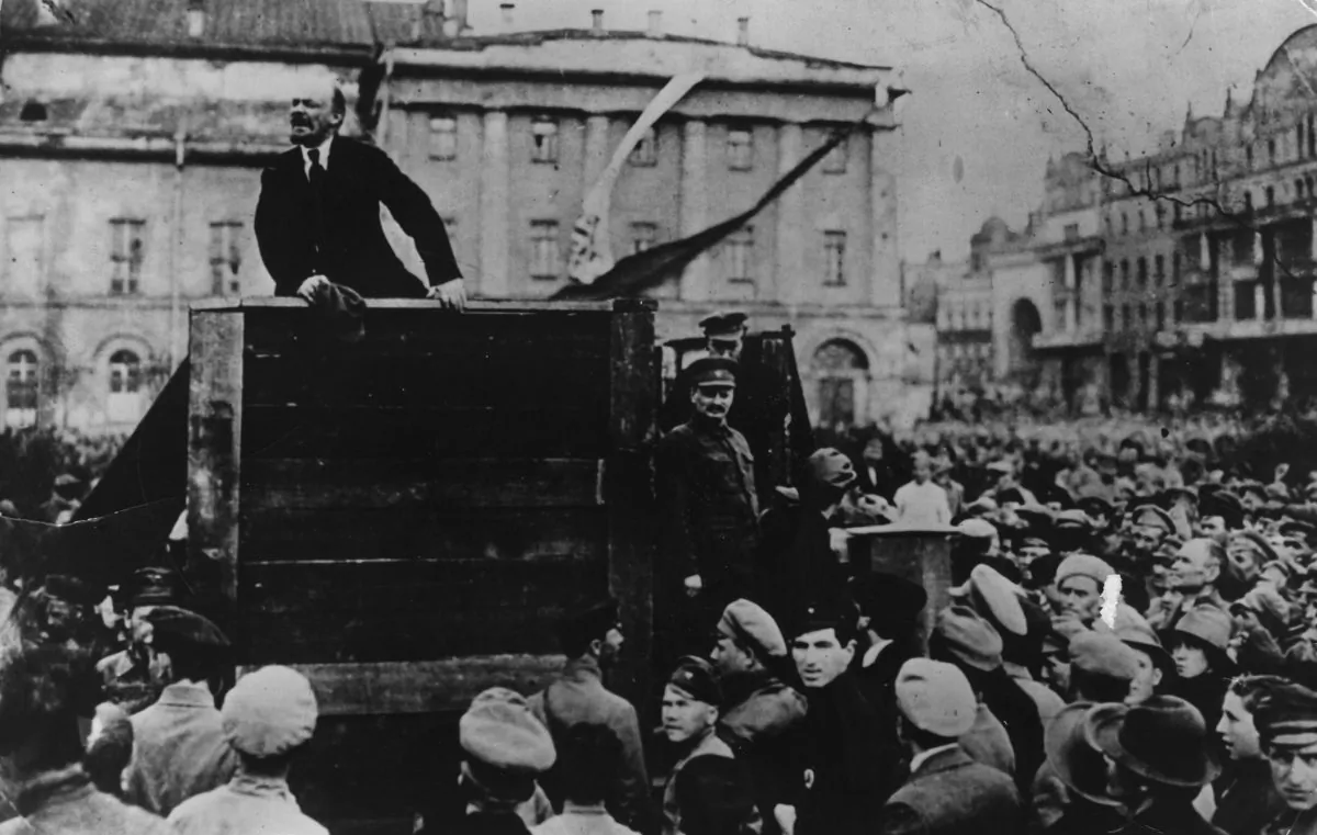 Russian communist revolutionary leader, Vladimir Lenin (1879 - 1924), giving a speech in to men of the Red Army leaving for the front, during the Polish-Soviet War, Sverdlov Square (now Theatre Square), Moscow, 5th May 1920. On the right of the platform are People's Commissar Leon Trotsky (1879 - 1940) and Politburo member Lev Kamenev (1883 - 1936). (Keystone/Getty Images)