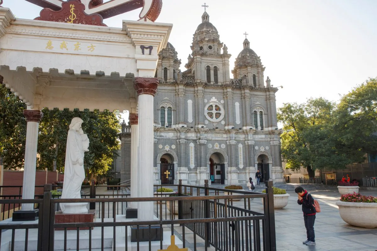 A believer prays outside St. Joseph's Church, a government-sanctioned Catholic church, in Beijing, China on Oct. 1, 2018. (Thomas Peter/Reuters)