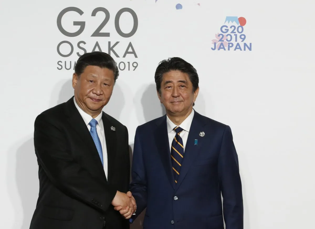 Chinese leader Xi Jinping welcomed by Japanese Prime Minister Shinzo Abe for a family photo session on the first day of the G20 summit in Osaka, Japan on June 28, 2019. (Kim Kyung-Hoon-Pool/Getty Images)