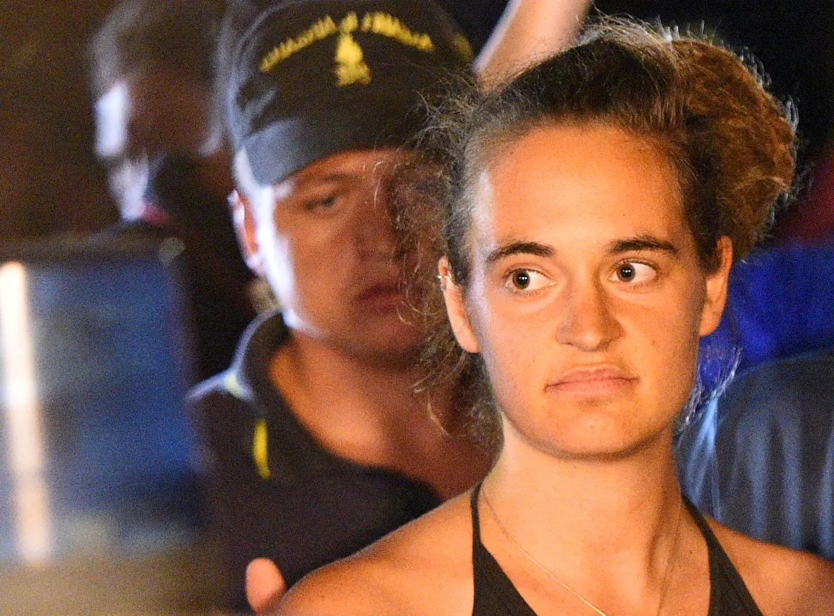 Carola Rackete, the 31-year-old Sea-Watch 3 captain, is escorted off the ship by police and taken away for questioning, in Lampedusa, Italy June 29, 2019. (Reuters/Guglielmo Mangiapane)