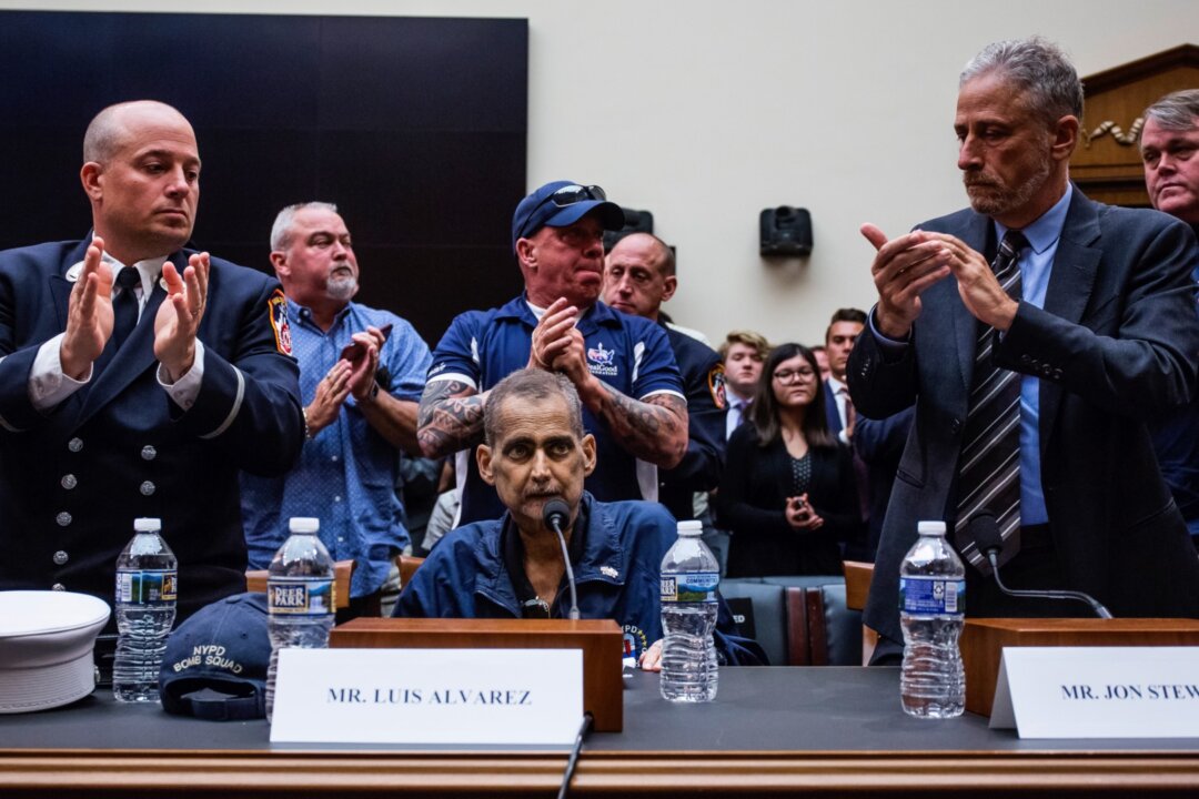 Retired Fire Department of New York Lieutenant and 9/11 responder Michael O'Connell, left, FealGood Foundation co-founder John Feal, center, and former Daily Show Host Jon Stewart, right, applaud following testimony from Retired New York Police Department detective and 9/11 responder Luis Alvarez during a House Judiciary Committee hearing on reauthorization of the September 11th Victim Compensation Fund on Capitol Hill in Washington on June 11, 2019. (Zach Gibson/Getty Images)
