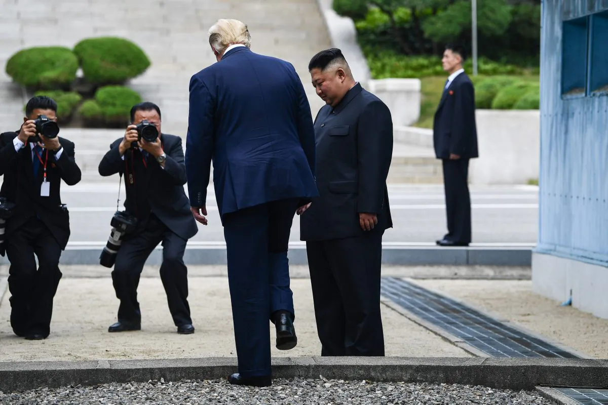 US President Donald Trump steps into the northern side of the Military Demarcation Line that divides North and South Korea, as North Korea's leader Kim Jong Un looks on, in the Joint Security Area (JSA) of Panmunjom in the Demilitarized zone (DMZ) on June 30, 2019. (Photo by Brendan Smialowski / AFP)        (Photo credit should read BRENDAN SMIALOWSKI/AFP/Getty Images)