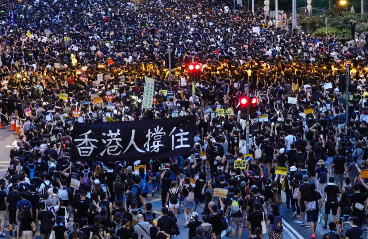Protesters holding a sign that reads "Hongkongers keep going" during the annual march in Hong Kong on July 1, 2019. (Yu Gang/The Epoch Times)