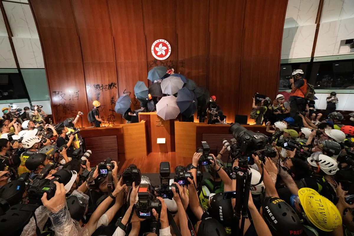 Protesters gather at the podium after they broke into the Legislature Council building in Hong Kong on July 1, 2019. (Li Yi/The Epoch Times)