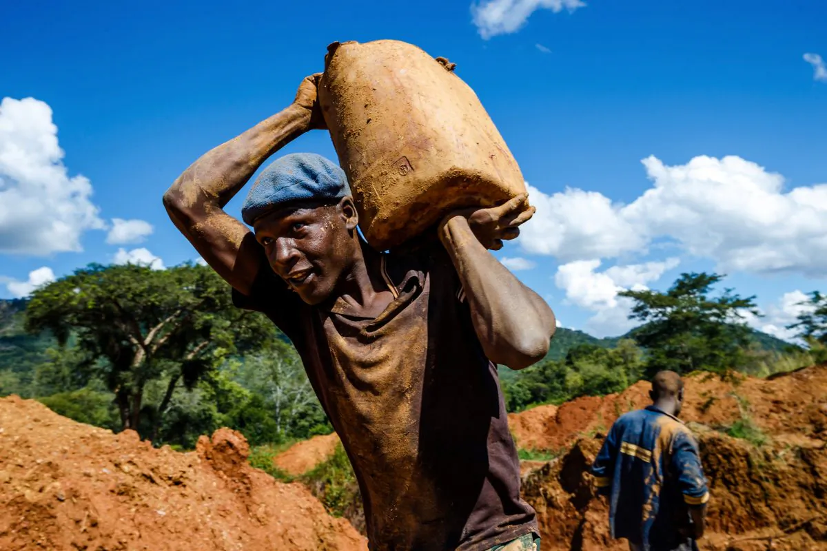A miner carries a load of ore at Manzou Farm, owned by Grace Mugabe, wife of former Zimbabwean President Robert Mugabe, in Mazowe, Zimbabwe on April 5, 2018. (Jekesai Njikizana/AFP/Getty Images)