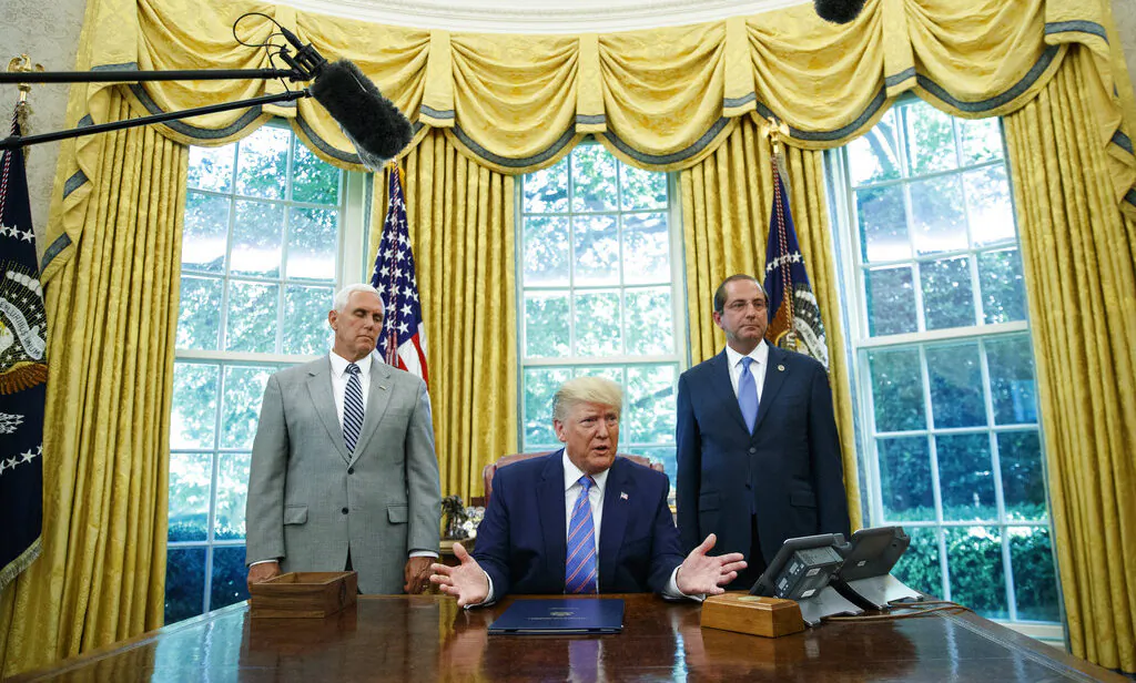 President Donald Trump, joined by Vice President Mike Pence, left, and Secretary of Health and Human Services Alex Azar, right, speaks during a signing ceremony in the Oval Office of the White House in Washington, Monday, July 1, 2019. The president signed a $4.6 billion aid package to help the federal government cope with the surge of Central American immigrants at the U.S.-Mexico border. (AP Photo/Carolyn Kaster)