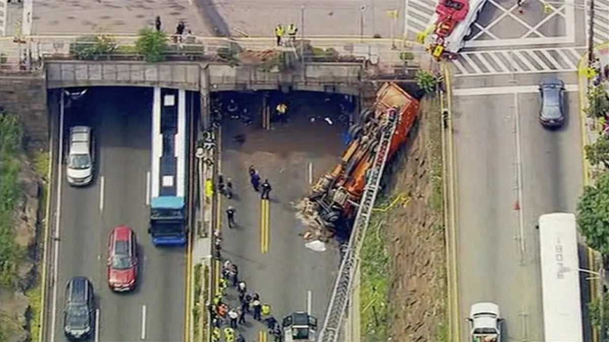 First responders work the scene after a garbage truck careened off an overpass onto the westbound lanes of Route 495, in Union City, N.J., on July 3, 2019. (WABC-TV via AP)