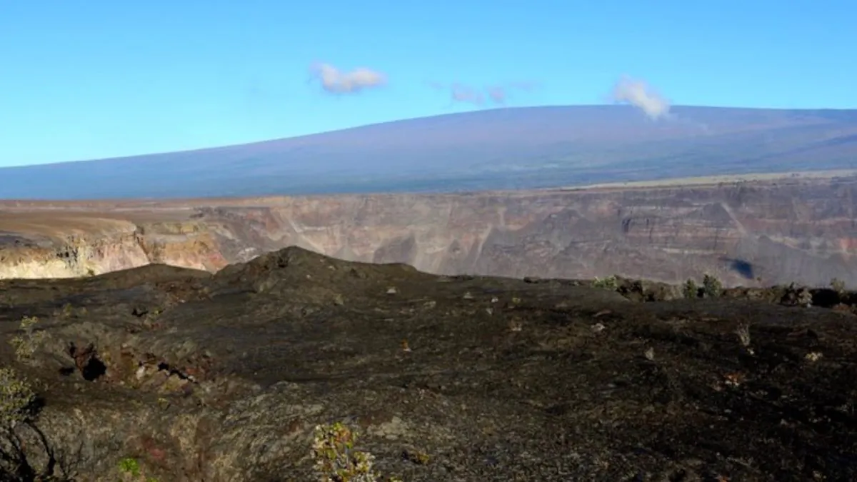 Hawaii's Mauna Loa volcano, background, towers over the summit crater of Kilauea volcano in Hawaii Volcanoes National Park on the Big Island on April 25, 2019. (Caleb Jones/Photo AP)