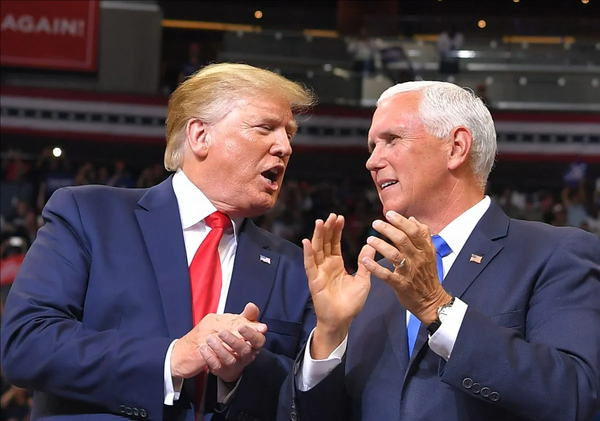 Vice President Mike Pence speaks with President Donald Trump at a rally to officially launch the Trump 2020 campaign, at the Amway Center in Orlando, Fla., on June 18, 2019. MANDEL NGAN/AFP/Getty Images