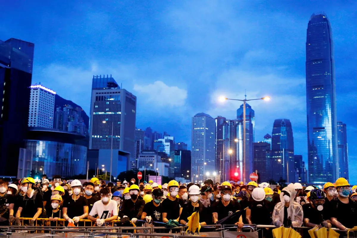 Anti-extradition bill protesters stand behind a barricade during a demonstration near a flag raising ceremony for the anniversary of Hong Kong handover to China in Hong Kong, China on July 1, 2019. (Tyrone Siu/Reuters)