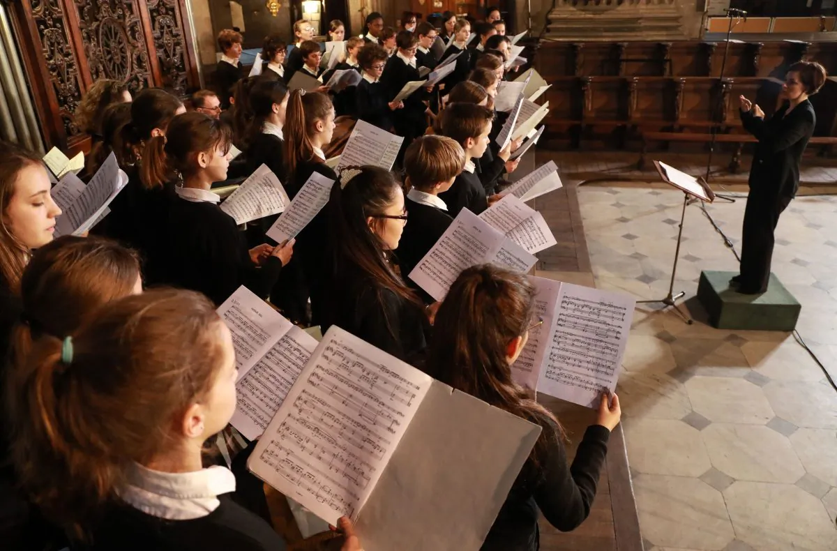 Emilie Fleury (R), head of the choir of children and the “Jeune Ensemble” of the Maitrise de Notre-Dame de Paris, conducts the choir in Saint-Sulpice Church in Paris, on April 18, 2019, after Notre-Dame Cathedral was devastated by a fire. (JACQUES DEMARTHON/AFP/Getty Images)
