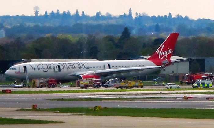 A Virgin Atlantic aircraft stands on the tarmac with emergency service vehicles after making an emergency landing at Gatwick Airport in London, England, on April 16, 2012. (Scott Heavey/File Photo via Getty Images)