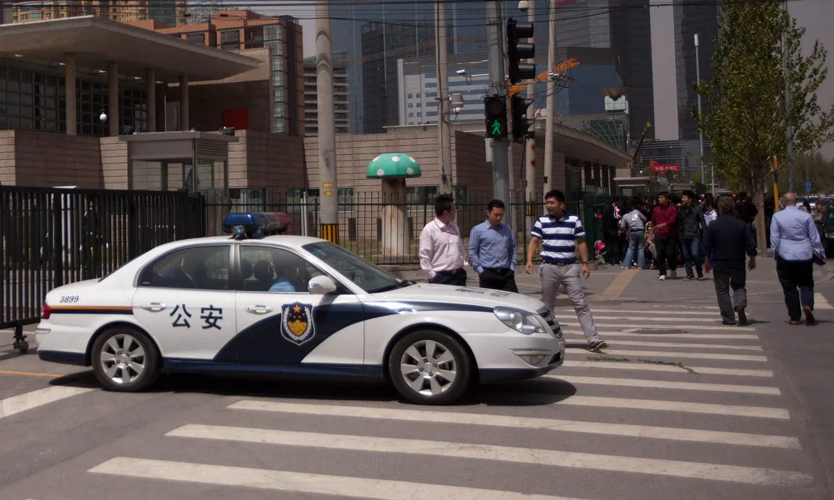 Chinese police car in front of a crowd. (Ed Jones/AFP/GettyImages)