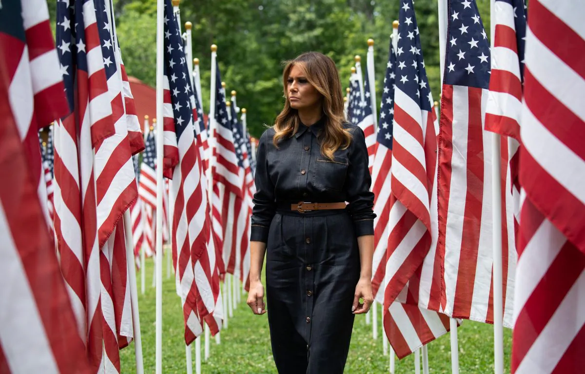 US First Lady Melania Trump walks through 453 American flags, each representing a child in foster care in Cabell County, West Virginia, many due to the opioid epidemic, at Ritter Park in Huntington, West Virginia, July 8, 2019. (SAUL LOEB/AFP/Getty Images)