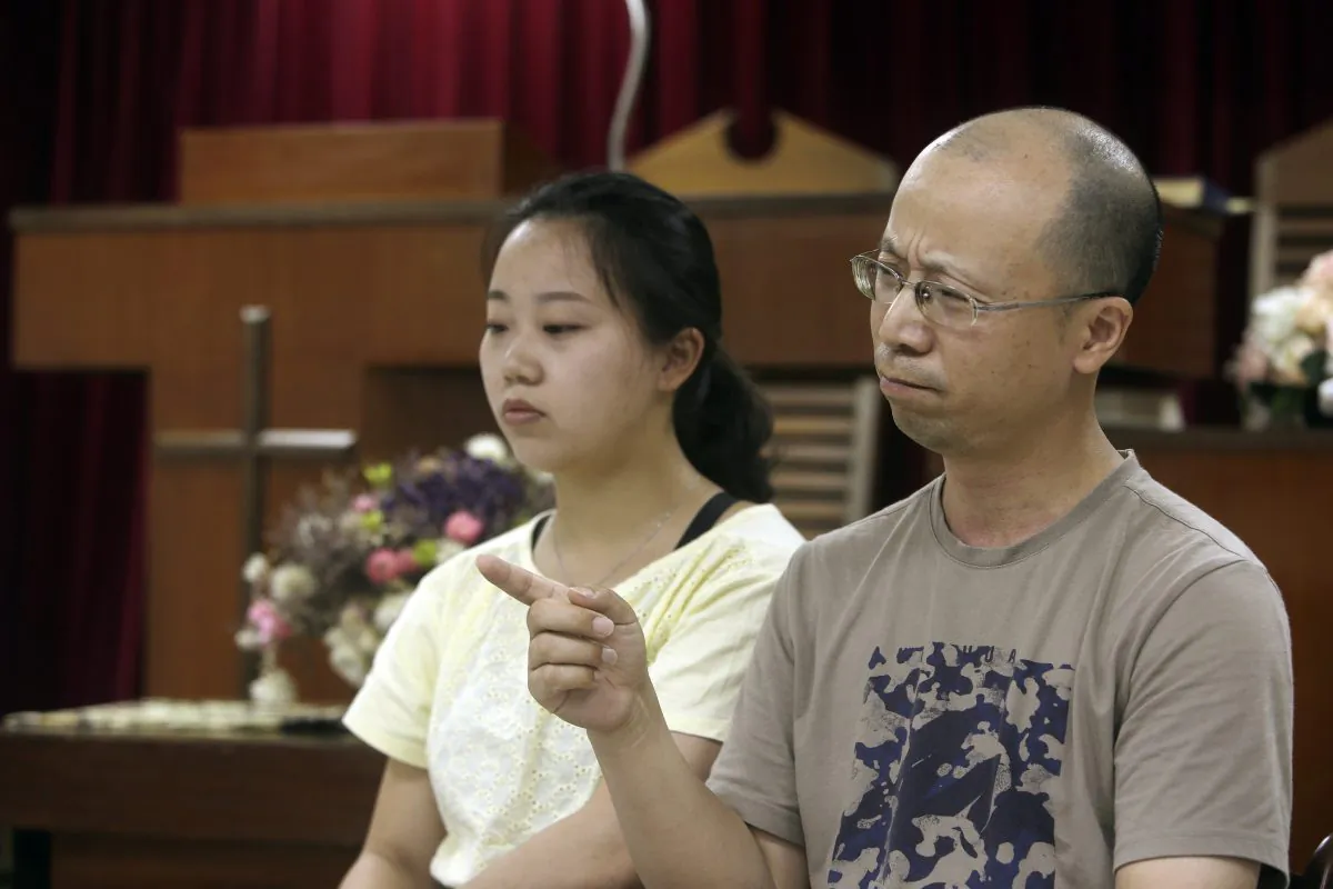 Liao Qiang, right, and his daughter Ren Ruiting speak during an exclusive interview with The Associated Press at a church in Taipei, Taiwan on July 7, 2019. (Chiang Ying-ying/AP)