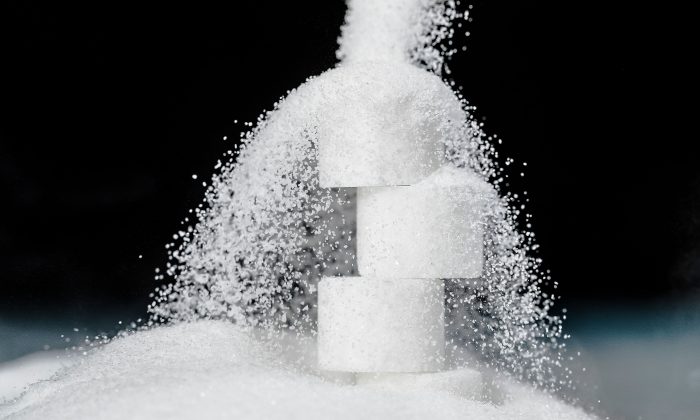 Sugar grains falling on an arrangement of white sugar cubes. (Joel Saget/AFP/Getty Images)