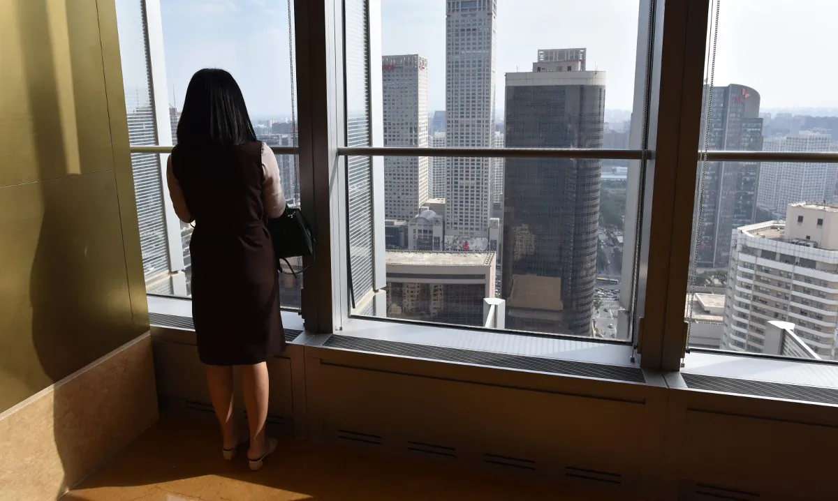 File footage of a woman looking out a building in China. (Greg Baker/AFP/Getty Images)