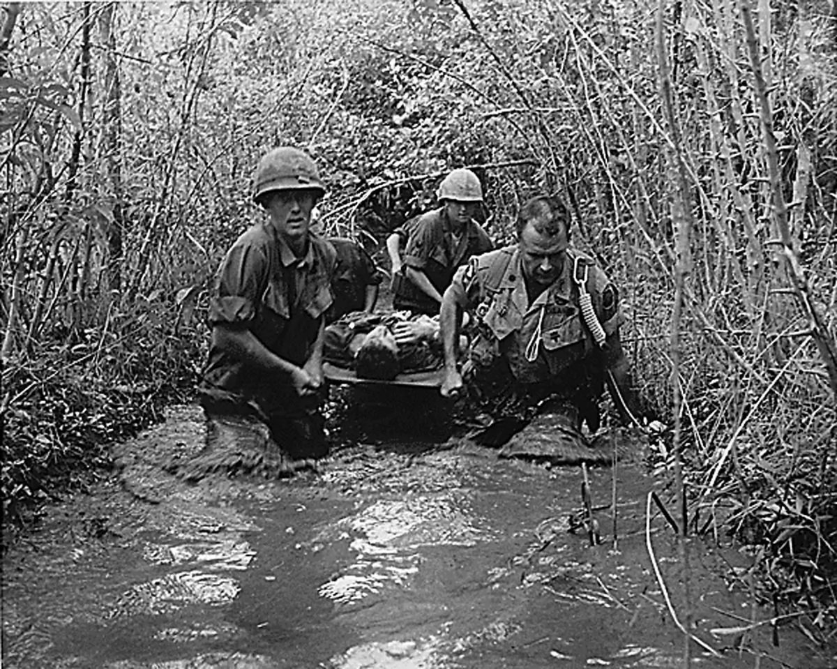 U.S. soldiers carry a wounded comrade through a swampy area during the Vietnam War in 1969. (National Archives/AFP/Getty Images)