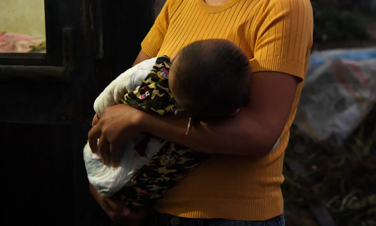 A woman holding a baby in China. (Greg Baker/AFP/Getty Images)