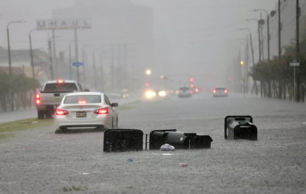 Vehicles head down a flooded Tulane Ave