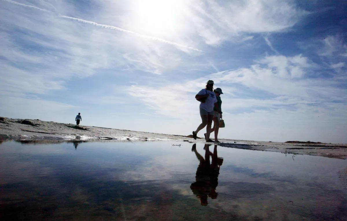 People walk on the beach on Sanibel Island, which neighbors Captiva, on Aug. 18, 2004. (Mario Tama/Getty Images)