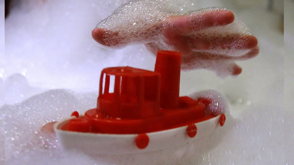 A child in a foam bath in a bath tub reaches for a plastic toy in a file photo. (Alexander Hassenstein/File Photo/Getty Images)