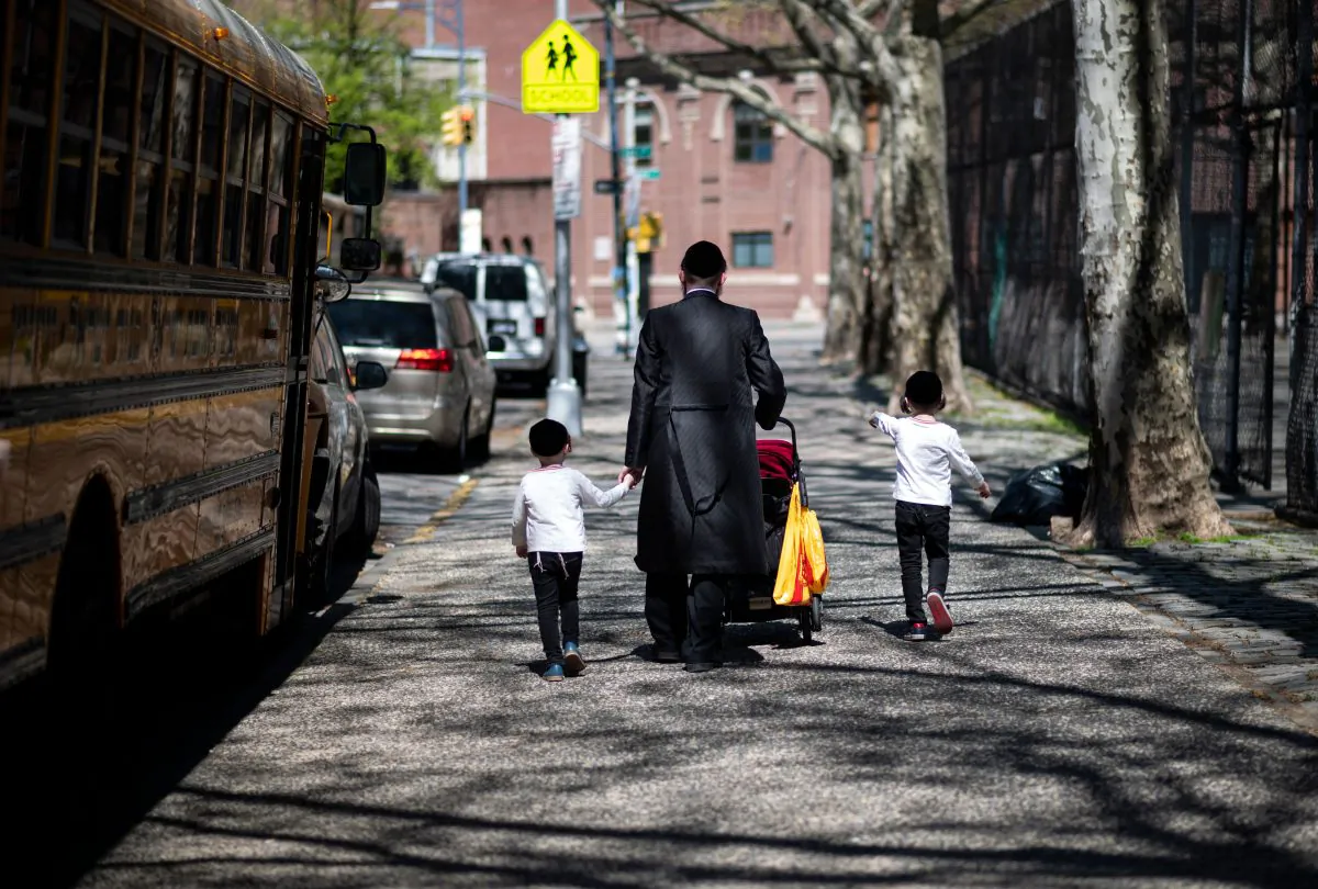 A Jewish man walks with his children down a street in a Jewish quarter in Williamsburg Brooklyn in New York City on April 24, 2019. (Johannes Eisele/AFP/Getty Images)