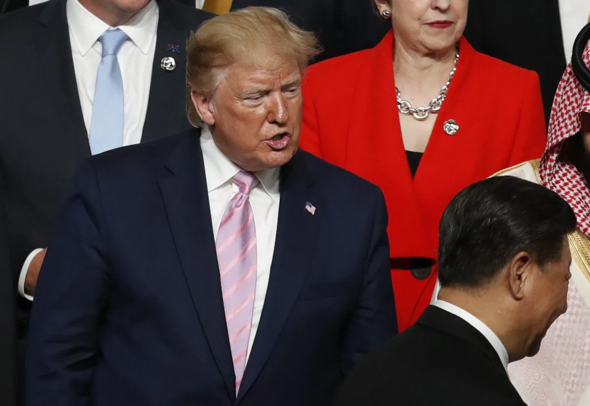 U.S. President Donald Trump (L) speaks to Chinese leader Xi Jinping after they shake hands at a family photo session at G20 summit in Osaka, Japan on June 28, 2019. (Kim Kyung-Hoon - Pool/Getty Images)