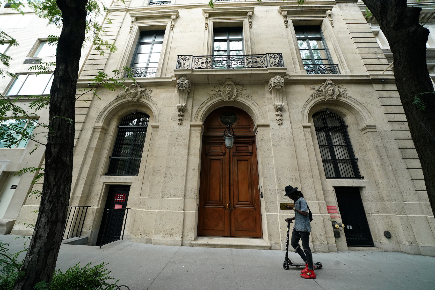 A man walks past the front door of the upper east side home of Jeffrey Epstein in New York