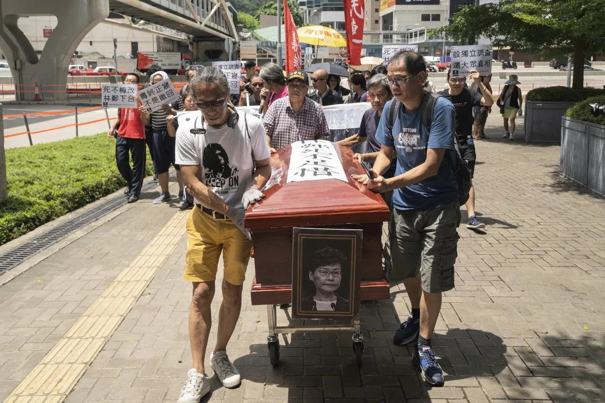 Protesters carry a mock coffin of city leader Carrie Lam as they parade against a controversial extradition bill around the government headquarters in Hong Kong on July 12, 2019. Lam on July 9 declared the legislation “dead,” but protesters insist that she formally withdraw the bill and quit. (Li Yi/The Epoch Times)