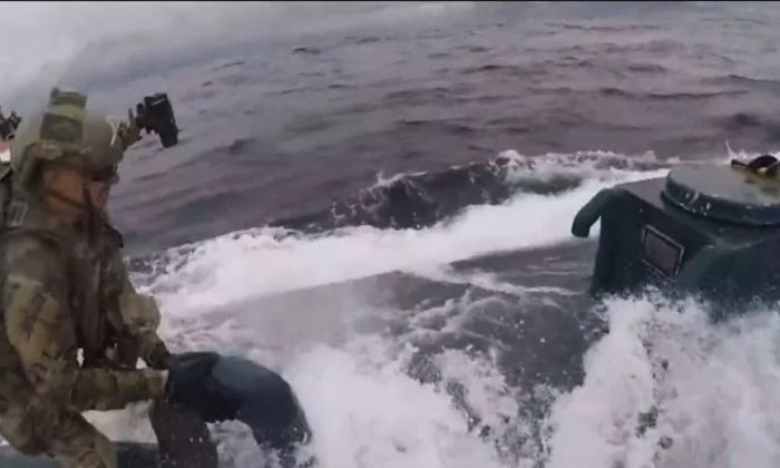 A U.S. Coast Guard member boards a suspected "narco sub" in the international waters of the Eastern Pacific Ocean on June 18, 2019. (U.S. Coast Guard)